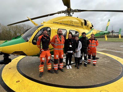 Doctor Jono Holme, critical care paramedic James Hubbard and Louise Cox with visitors from The James Dyson Foundation in front of the Wiltshire Air Ambulance helicopter.