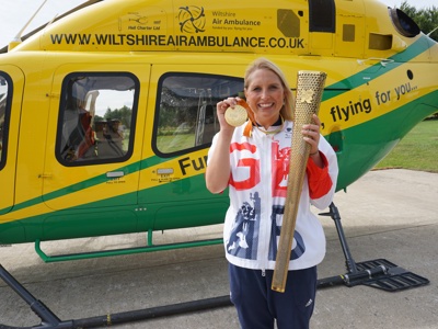 Stephanie Millward holding the Olympic torch and medal