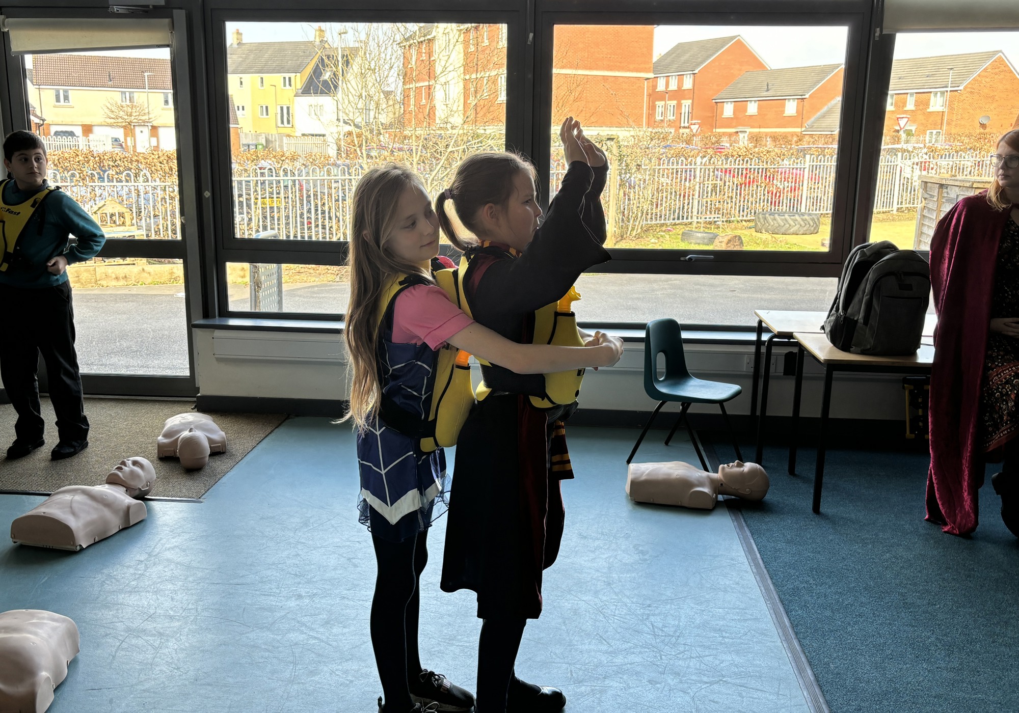 Two school girls practicing an abdominal thrust