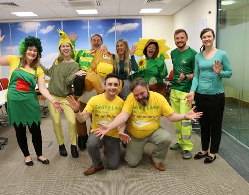 A group of colleagues wearing green and yellow attire to raise funds for Wiltshire Air Ambulance during Air Ambulance week. 