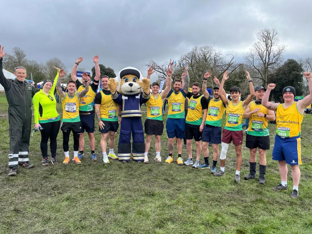 A group of runners from the Bath Half marathon, posing with a mascot 