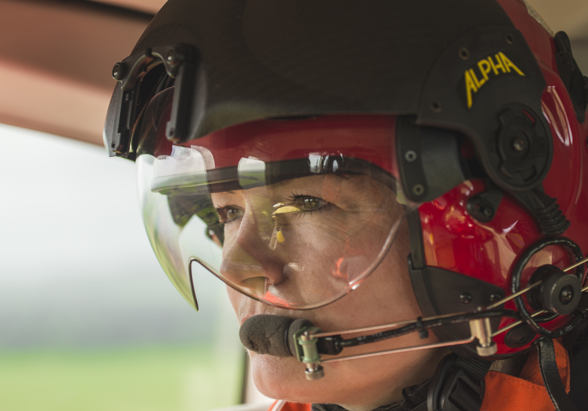 A female paramedic wearing a red flight helmet
