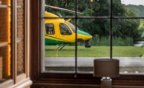 A yellow and green helicopter views through a paned window