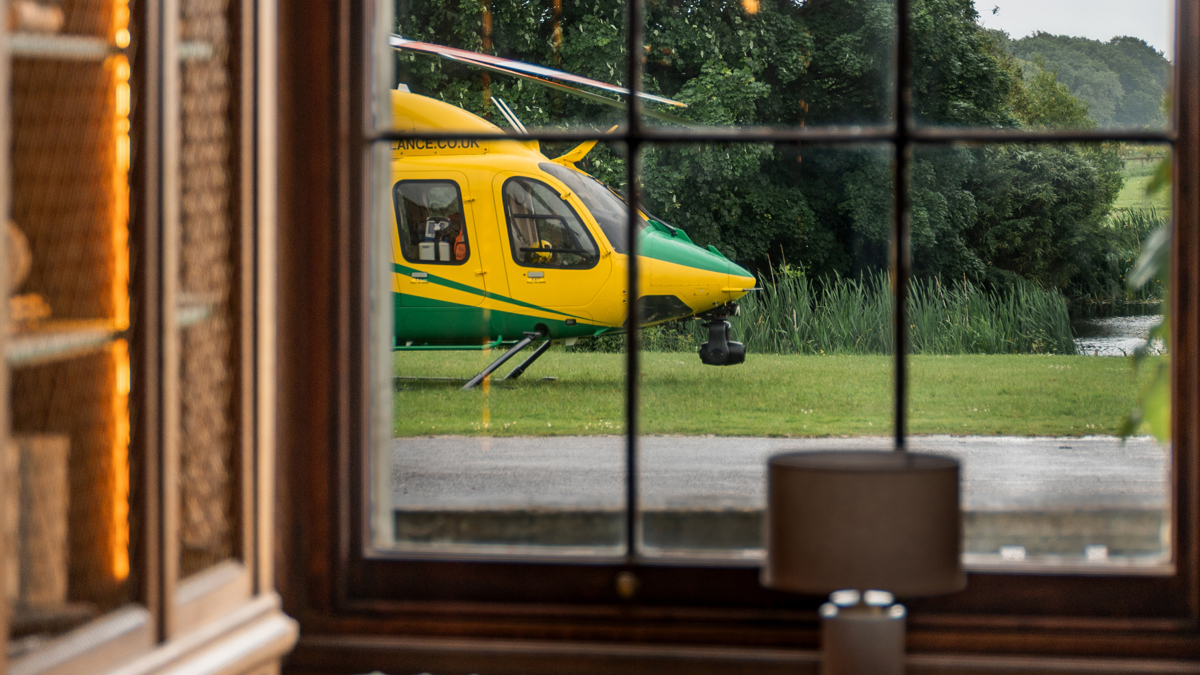 A yellow and green helicopter views through a paned window
