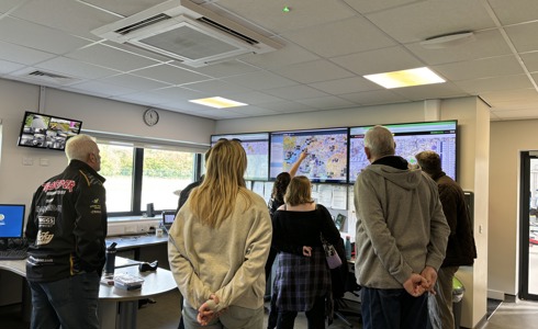 A group of people being shown screens in a flight room