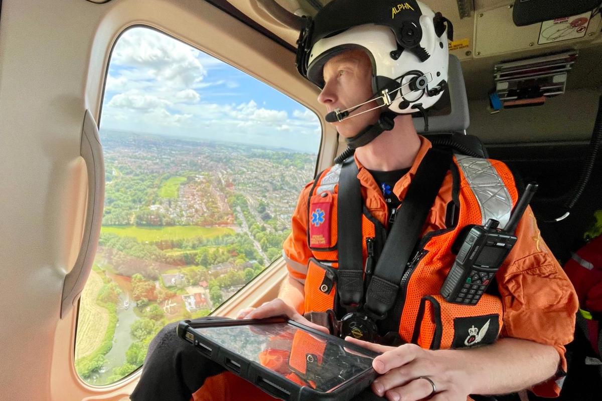 A critical care paramedic in flight looking over Wiltshire countryside