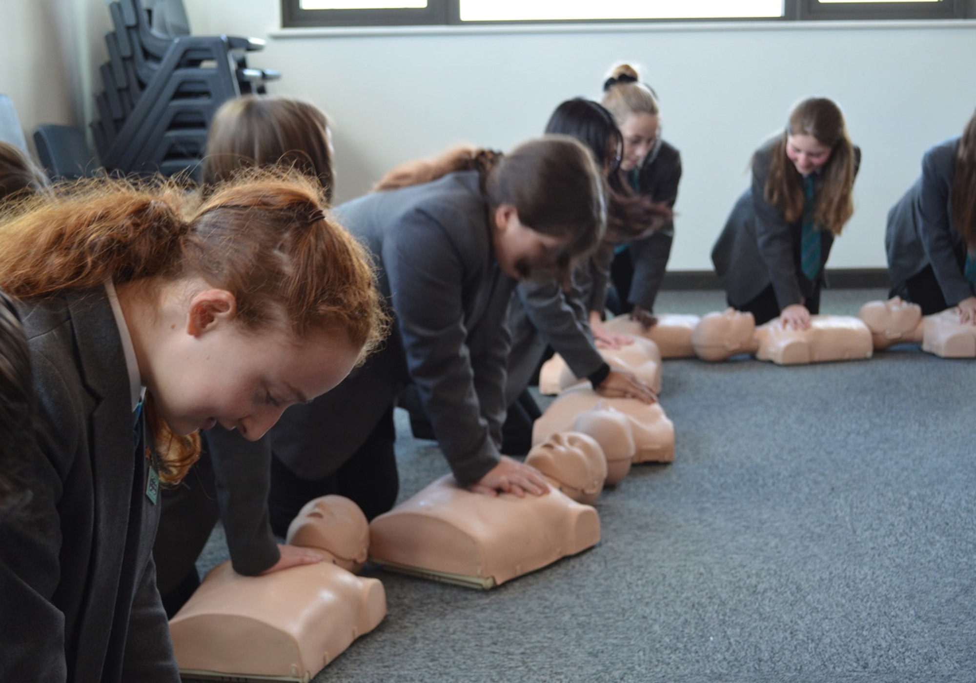 School children practicing CPR on a manekin