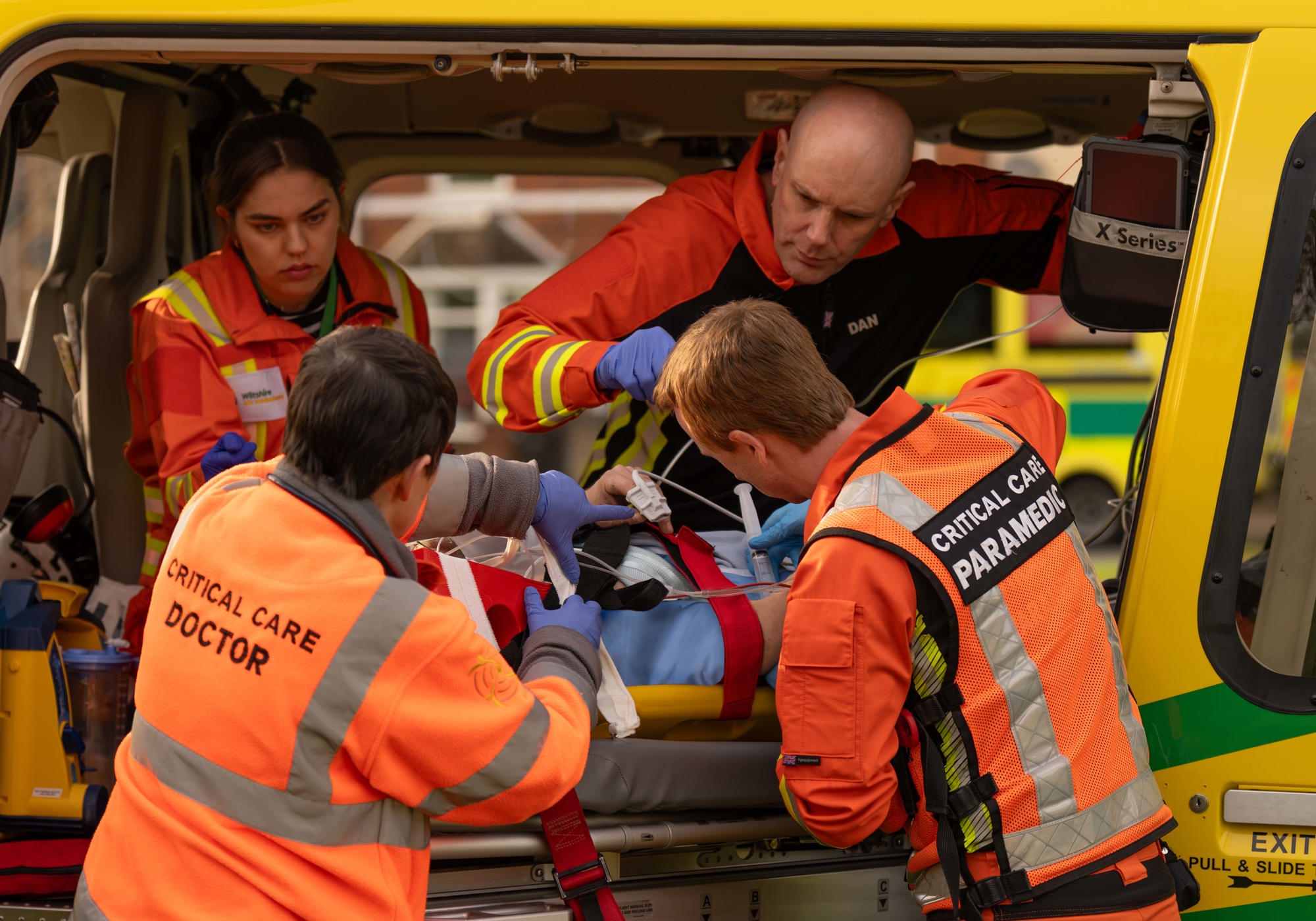 A team of critical care paramedics and doctors working on a patient on a stretcher in the back of the charity's helicopter